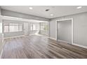 Bright living room featuring wood-look flooring, many windows with blinds, and a closet at 1002 Fruitland Ave, Bradenton, FL 34207