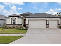 Inviting single-story home featuring a 3-car garage, stone accents, and a well-manicured front yard at 1043 Davis Heather Cir, Seffner, FL 33584