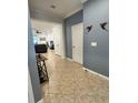 Hallway leading to a living space with tile flooring and blue colored walls at 11248 Mollymawk Ct, New Port Richey, FL 34654