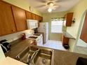 Well-equipped kitchen featuring wood cabinets, white appliances, and ample counter space at 1473 Feather Dr # 1473, Clearwater, FL 33759