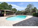 Inviting pool area with covered outdoor bar and ample patio space for entertaining at 14809 Ninebark Ct, Land O Lakes, FL 34638