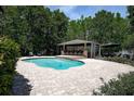 An in-ground pool with an outdoor kitchen provides a great area to entertain in this well-maintained yard at 14809 Ninebark Ct, Land O Lakes, FL 34638