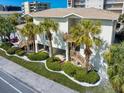 Inviting Beachside Villas featuring exterior stairs, lush palms and verdant landscaping at 1500 Gulf Blvd # 103B, Indian Rocks Beach, FL 33785
