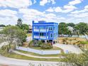 Stunning blue two-story home with beautiful landscaping and a white fence at 228 Shore Dr, Tarpon Springs, FL 34689