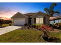 Charming single-story home with well-kept lawn and garden under dusk sky at 25317 E Lenox Cir, Punta Gorda, FL 33950