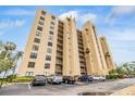 Tall condominium building featuring balconies and a well-maintained parking area at 2616 Cove Cay Dr # 301, Clearwater, FL 33760