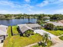 Aerial view of a lovely single-Gathering home with a spacious yard, nestled beside a serene lake and neighboring houses at 2924 Catherine Dr, Clearwater, FL 33759