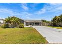 Charming single Gathering home featuring a stone accent wall, well-manicured lawn, and a freshly painted gray exterior at 2924 Catherine Dr, Clearwater, FL 33759