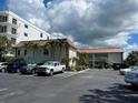 Exterior shot showcasing the building's architecture, landscaping, and parking area with multiple cars at 333 Island Way # 203, Clearwater Beach, FL 33767