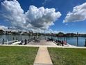 Scenic waterfront featuring a wooden dock and lush green lawn, ideal for tranquil enjoyment and recreation at 333 Island Way # 203, Clearwater Beach, FL 33767