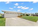 Exterior view of a white home with a spacious driveway and well-maintained lawn at 3545 97Th N Ave # 4, Pinellas Park, FL 33782