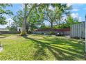 Expansive backyard features a lush lawn, mature trees and plenty of space for outdoor activities at 3910 W Comanche Ave, Tampa, FL 33614
