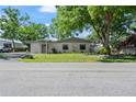 Charming home with a well-kept lawn, mature trees, and a welcoming facade at 3910 W Comanche Ave, Tampa, FL 33614