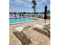 Community pool featuring lounge chairs, umbrellas, and beautiful waterfront views at 400 64Th Ave # 202, St Pete Beach, FL 33706
