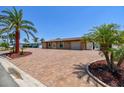 Inviting one-story home with a paver driveway, picturesque landscaping, and a two-car garage at 4011 99Th W St, Bradenton, FL 34210