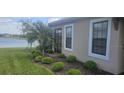 Side view of the house featuring lush landscaping, patio access, and stunning water view at 5406 Rushmere Ct, Palmetto, FL 34221