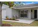 Cozy front porch with chairs and decorative plants creates a welcoming entrance to the home at 6712 Jennifer Dr, Temple Terrace, FL 33617