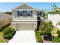 Inviting two-story home with a manicured lawn, neutral exterior, and attached two-car garage at 7486 Tuscan Bay Cir, Wesley Chapel, FL 33545