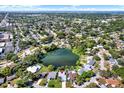 Expansive aerial view showcasing the neighborhood's serene lake and lush greenery, highlighting the property's prime location at 10828 99Th Pl, Seminole, FL 33772