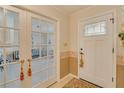Inviting foyer with tile flooring and French doors leading to a living area provides a warm greeting at 1104 Northridge Dr, Palm Harbor, FL 34683