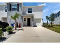 Daytime view of a modern townhome featuring a one-car garage, landscaped front yard, and neutral exterior colors at 138 Mangrove Shade Cir, Apollo Beach, FL 33572