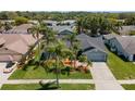 Aerial view of home featuring well-maintained lawn, mature landscaping, and a paved driveway at 1805 Stable Trl, Palm Harbor, FL 34685