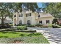 Attractive two-story home with manicured lawn, mature trees, and well-maintained garden in a serene setting at 1927 Curry Rd, Lutz, FL 33549
