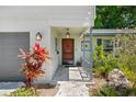 Charming front entrance with a covered porch, stone walkway, and fresh landscaping at 2525 Madrid S Way, St Petersburg, FL 33712