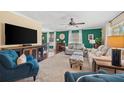 Comfortable living room with sofas, chairs, large windows, green walls, and media center at 2525 Madrid S Way, St Petersburg, FL 33712