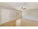 Open-concept living room featuring tile floors, a ceiling fan, and a sunlit window at 2690 Coral Landings Blvd # 122, Palm Harbor, FL 34684