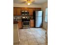 Well-lit kitchen with wooden cabinets, stainless steel appliances including stainless refrigerator at 2961 Flint N Dr, Clearwater, FL 33759
