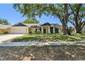 Charming single-story home features an attached garage and a beautifully landscaped front yard with mature trees at 3041 Avalon Terrace Dr, Valrico, FL 33596