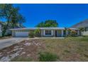 Inviting single-story home with a brick facade, two-car garage, and well-kept landscaping at 3133 Pineview Dr, Holiday, FL 34691