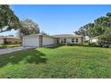 Charming single-story home featuring a two-car garage, stone accents, and a well-maintained lawn at 4148 102Nd N Pl, Clearwater, FL 33762
