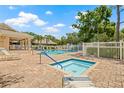 Community pool and spa area surrounded by brick patio and lush landscaping, perfect for relaxation at 476 Santa Cruz Ne Pl # C, St Petersburg, FL 33703