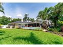 Expansive backyard showcasing lush green lawn, mature trees, a sparkling pool, and outdoor seating at 500 Tallahassee Ne Dr, St Petersburg, FL 33702