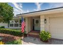 Charming front porch with decorative door, beautiful flag, and lush landscaping at 500 Tallahassee Ne Dr, St Petersburg, FL 33702
