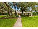 Inviting two-story home with lush green lawn, mature trees, and a charming front exterior at 5902 Audubon Manor Blvd, Lithia, FL 33547