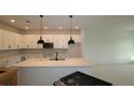 Bright kitchen with white cabinets, a spacious island, and modern pendant lighting fixtures at 6270 Broad Field Ave, Apollo Beach, FL 33572