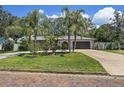 Beautiful single-story home featuring mature landscaping and palm trees along the front walkway at 6821 Date Palm S Ave, St Petersburg, FL 33707