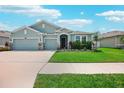 Charming single-story home features a three-car garage, manicured lawn, and a welcoming front entrance at 7323 Steer Blade Dr, Zephyrhills, FL 33541