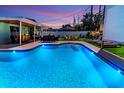 An inviting backyard pool area with outdoor seating and lush landscaping offers a perfect relaxation and entertainment space at 7530 85Th Ln, Seminole, FL 33777