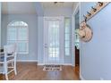Inviting foyer with hardwood floors, a charming door curtain, and a decorative wall rack at 7824 Primula Ln, New Port Richey, FL 34654