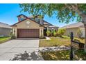 Inviting exterior with a two-car garage, arched entryway, fresh landscaping, and a well-manicured lawn at 8103 Tar Hollow Dr, Gibsonton, FL 33534