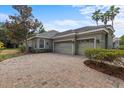 Spacious three-car garage with a brick paver driveway and well-maintained landscaping at 8463 Dunham Station Dr, Tampa, FL 33647