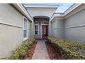 Inviting entryway with a red front door framed by sidelights and manicured shrubbery at 8463 Dunham Station Dr, Tampa, FL 33647
