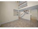 Spacious living room with high ceilings, staircase, and neutral color palette at 962 Marco Ne Dr, St Petersburg, FL 33702