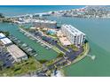 Aerial view of the waterfront condominium complex with marina, boat slips, and swimming pool at 1 Key Capri # 211W, Treasure Island, FL 33706