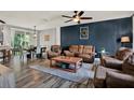 Cozy living room featuring hardwood floors, a ceiling fan, and comfortable seating area at 11041 Black Swan Ct, Seffner, FL 33584