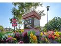 West Lake brick community sign surrounded by colorful flowers, with blue sky and greenery in the background at 11548 Crowned Sparrow Ln, Tampa, FL 33626